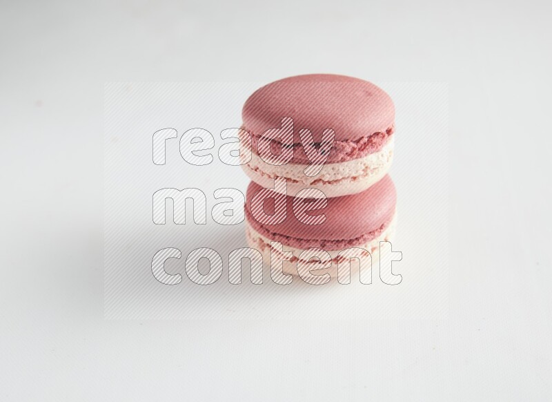 45º Shot of two Pink Litchi Raspberry macarons on white background