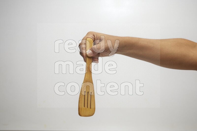 Male Hand Holding Slotted Turner on white background
