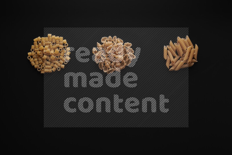 Different pasta types in bunches on black background