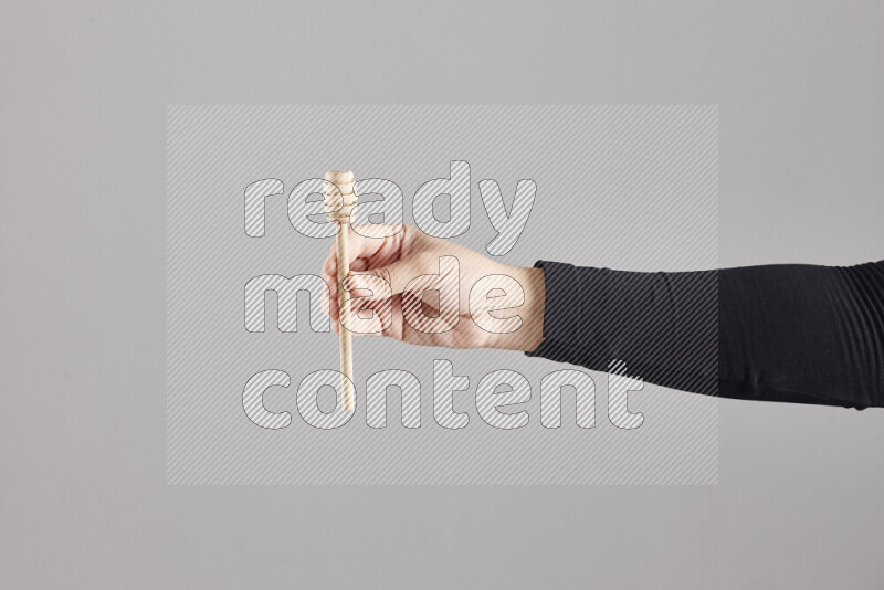 امرأة ترتدي عباءة سوداء تحمل أدوات خشبية مختلفة في أوضاع متعددة