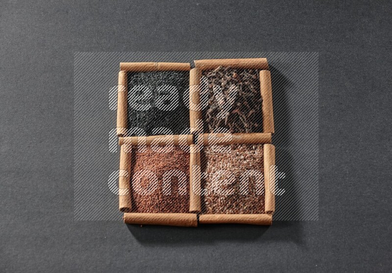 4 مربعات من عيدان القرفة ممتلئة بحبة البركة السوداء وحب الرشاد وبذور الكتان والقرنفل على أرضية سوداء