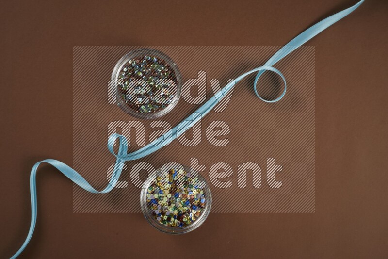 مجموعة من أدوات الخياطة والتفصيل زرقاء اللون على خلفية بنية