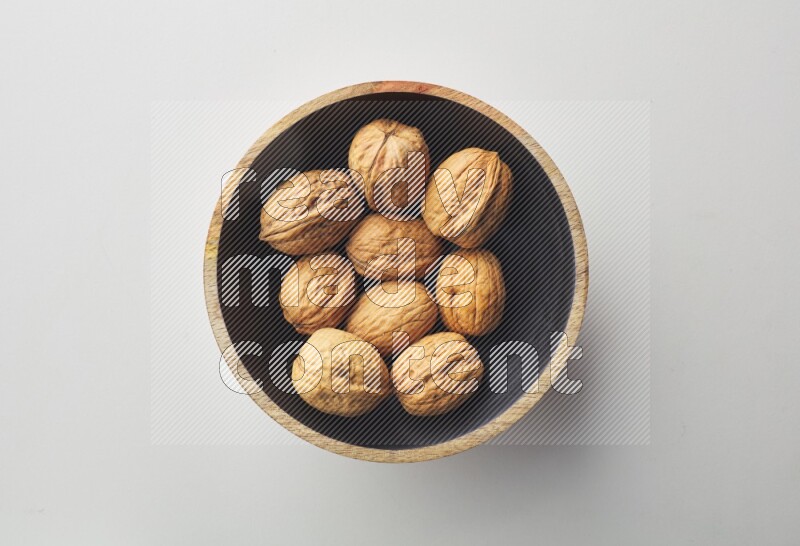 Top-view shot of walnut in a container on white background