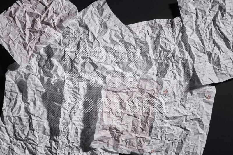 Crumpled notebook sheet on black background