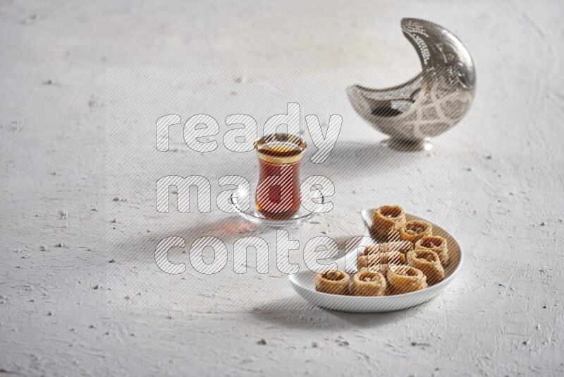 Konafa in a pottery plate with lantern and tea in a light setup