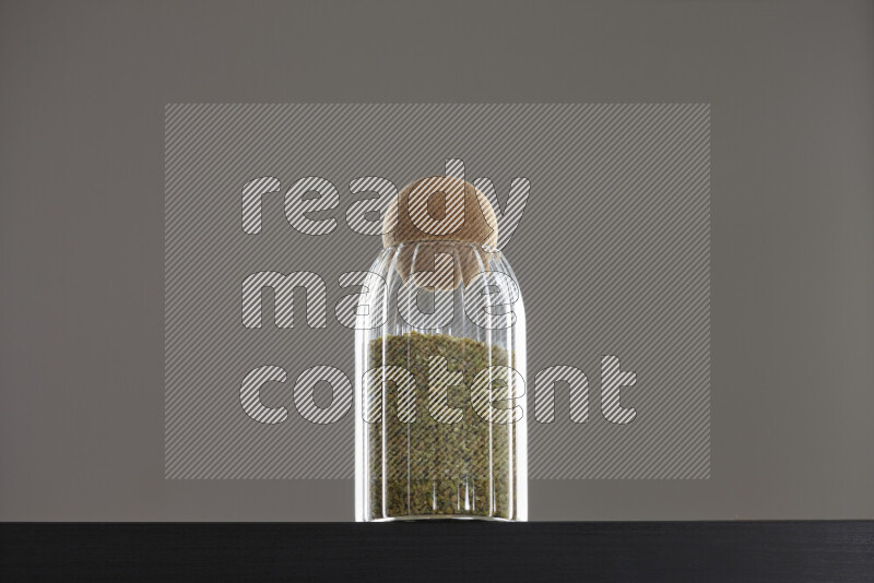 Freekeh in a glass jar on black background