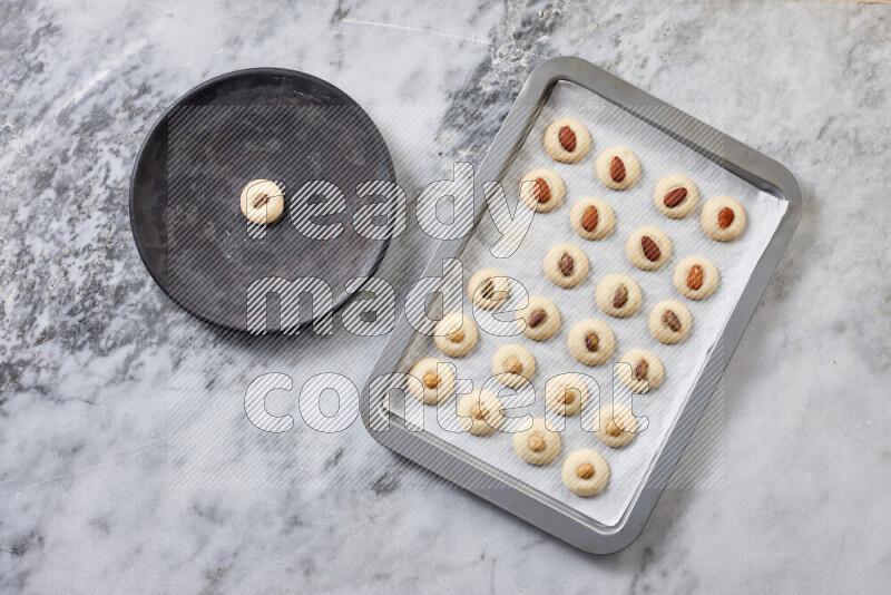 غريبة خطوة بخطوة بالمكونات الدقيق والسكر البودرة والسمن والمكسرات على خلفية رخام رمادي