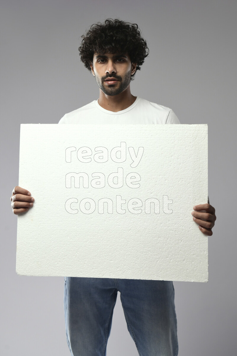 A man wearing casual standing and holding a white board on white background