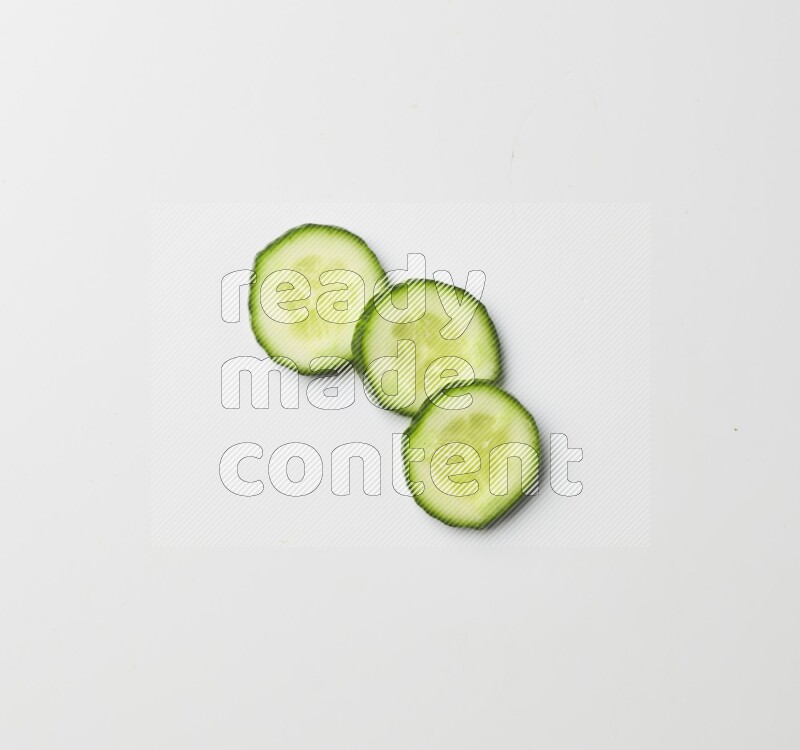 three cucumber slices on white background