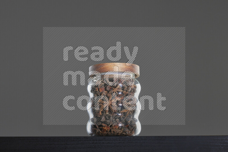 Star anise in a glass jar on black background
