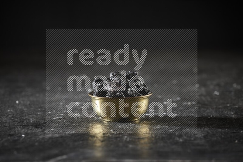 فواكه مجففة في وعاء معدني علي خلفية سوداء