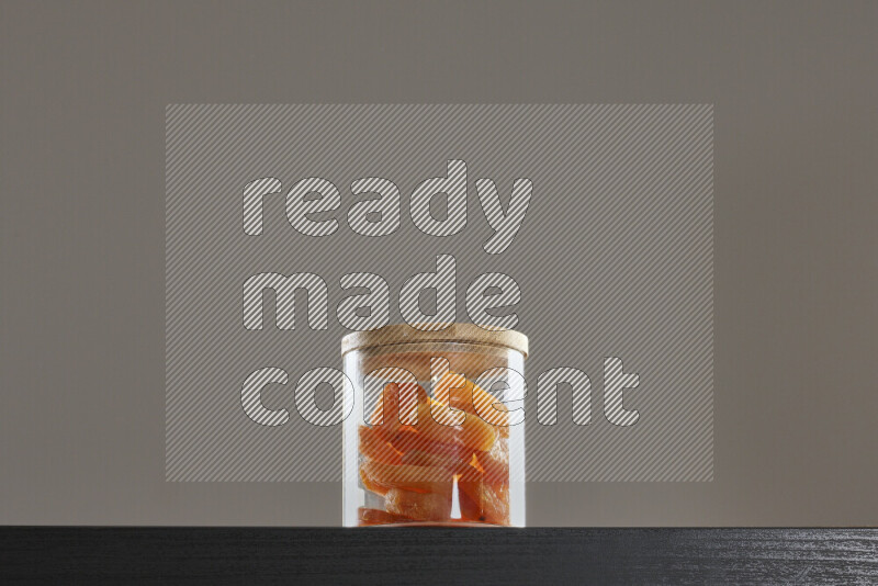 Dried apricots in a glass jar on black background