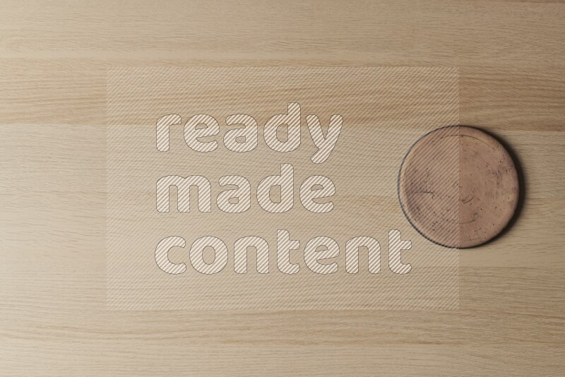 A pottery coaster on light wooden background