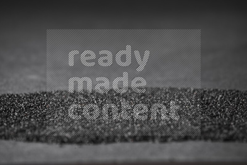 Black seeds filling the frame on a black flooring