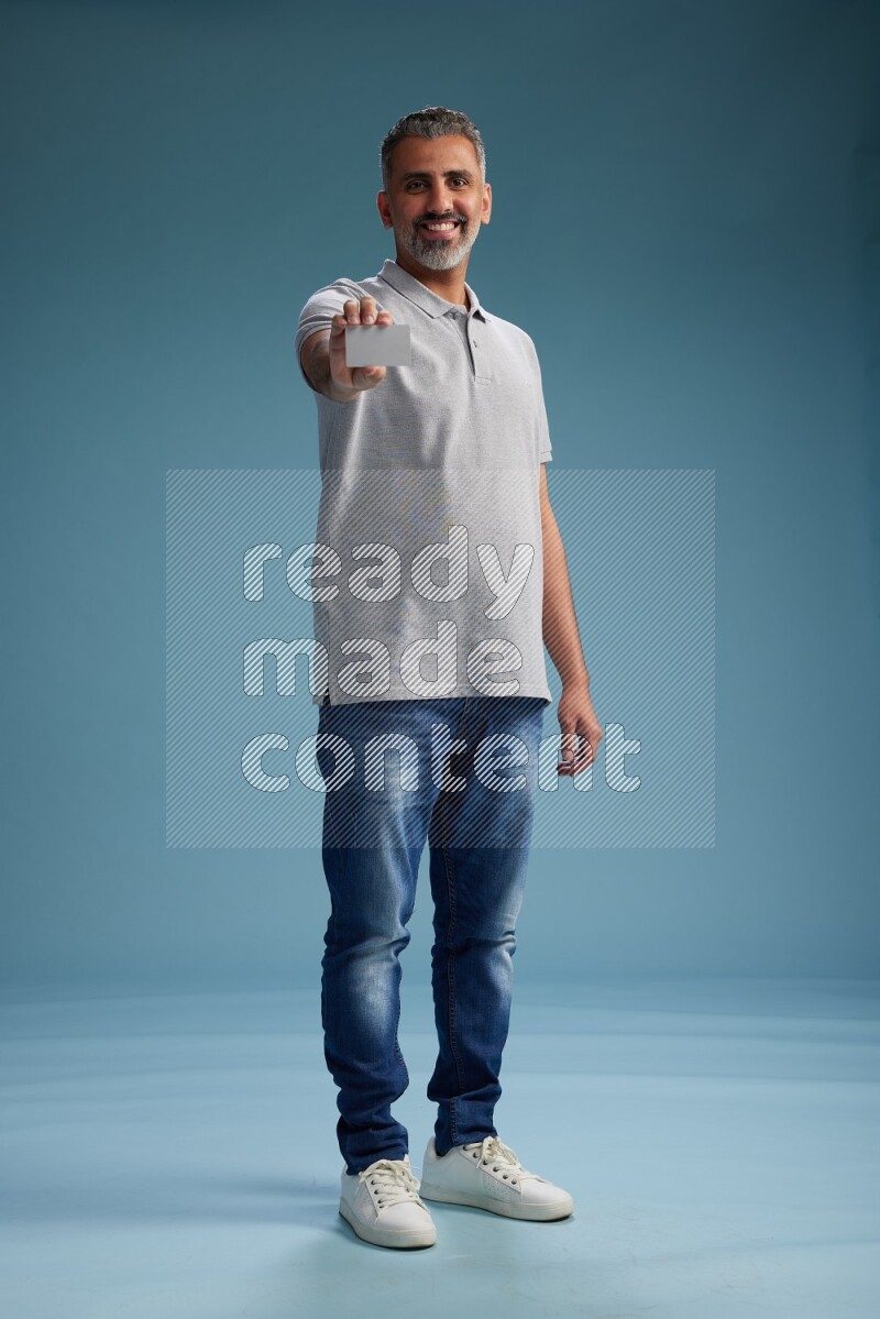 Man Standing holding ATM on blue background