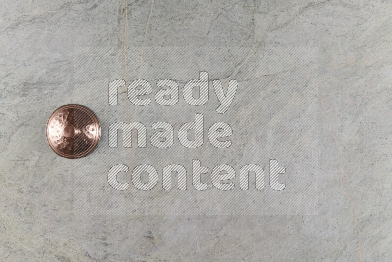 A small copper pot on grey marble background
