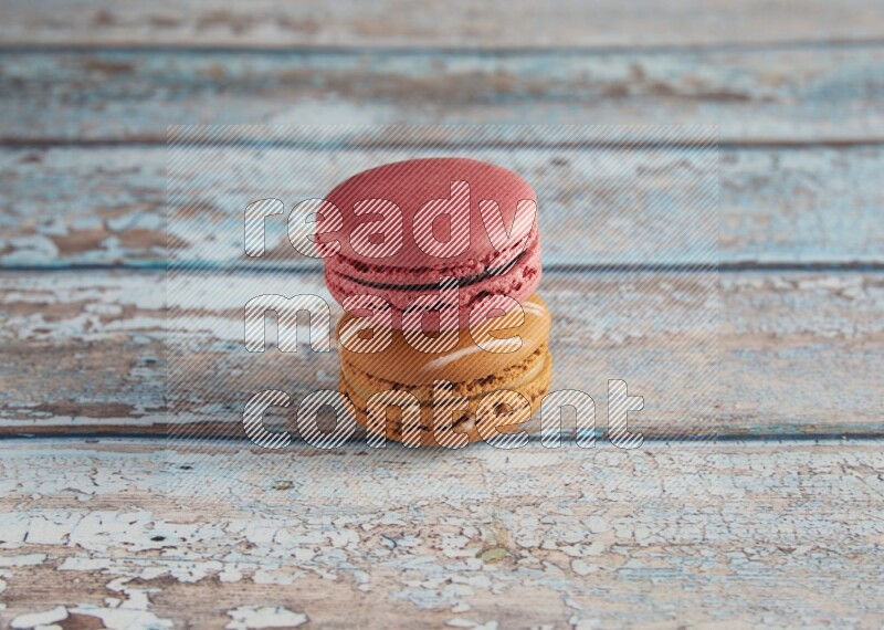 45º Shot of of two assorted Brown Irish Cream, and Pink Raspberry macarons on light blue background