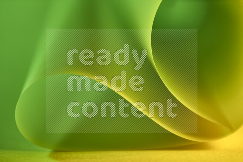 An abstract art piece displaying smooth curves in green and yellow gradients created by colored light