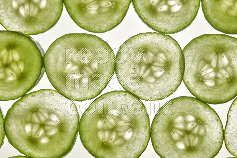 Cucumber slices on illuminated white background