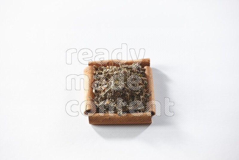 A single square of cinnamon sticks full of dried basil on white flooring
