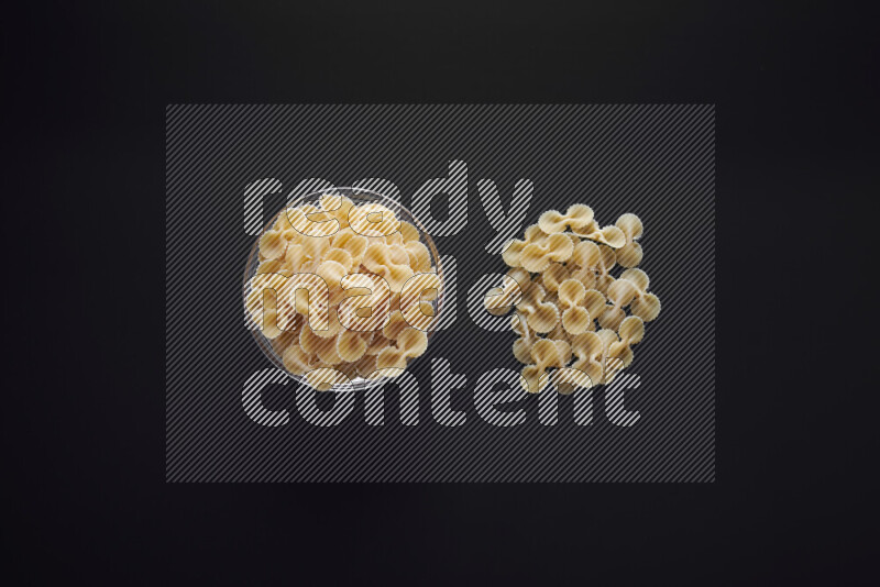 معكرونة فيونكة في وعاء زجاجي علي خلفية سوداء
