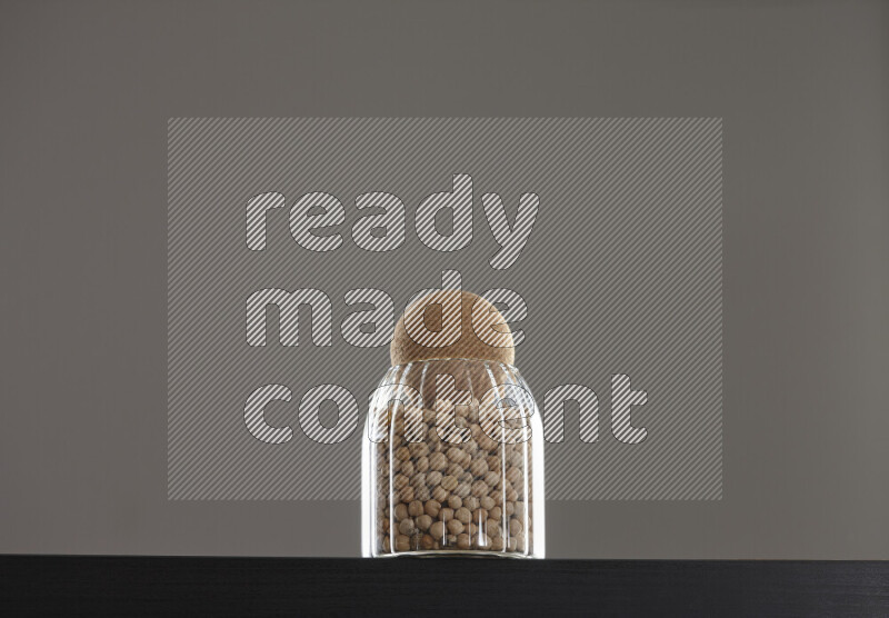 Chickpeas in a glass jar on black background