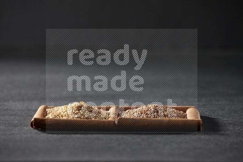 2 squares of cinnamon sticks full of mustard seeds and sesame on black flooring