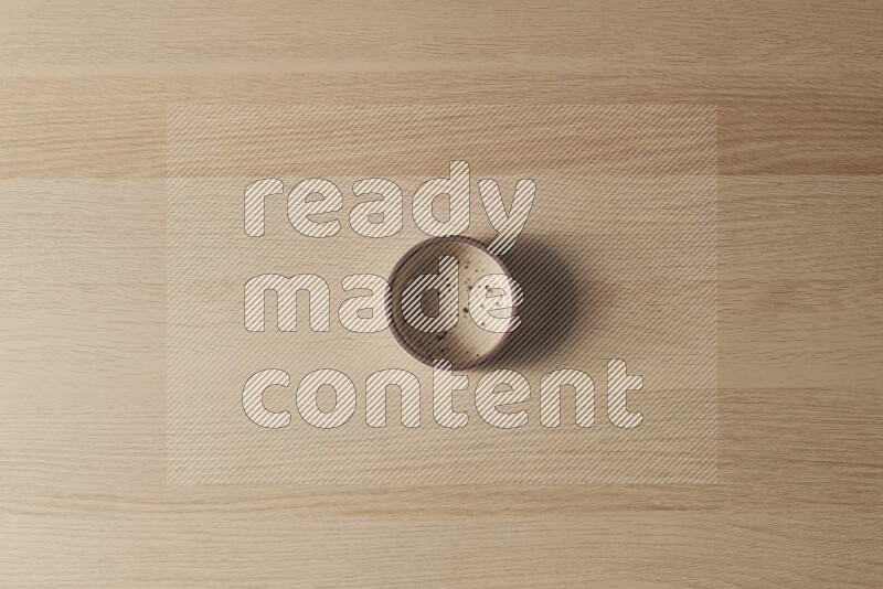 A multicolored pottery oven plate on light wooden background