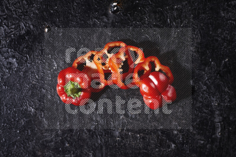 Red bell pepper slices on black background