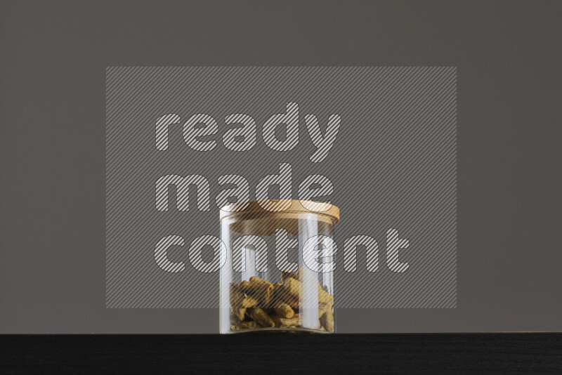 Turmeric in a glass jar on black background