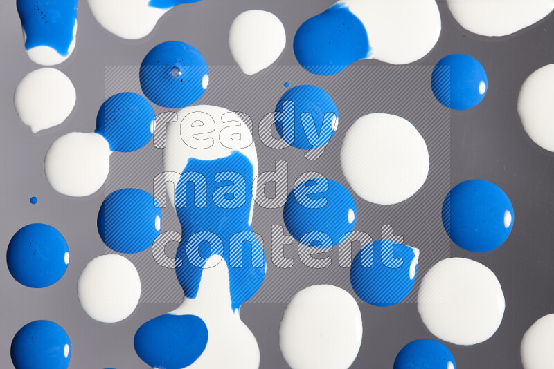 Close-ups of abstract white and blue paint droplets on the surface
