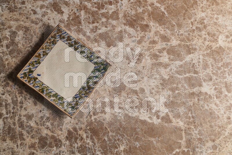 A decorative pottery plate on beige marble background