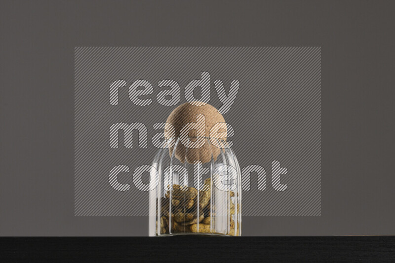 Turmeric in a glass jar on black background