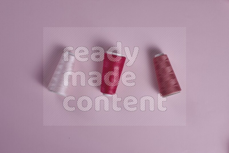 A pink collection of sewing and tailoring tools arranged on a pink background