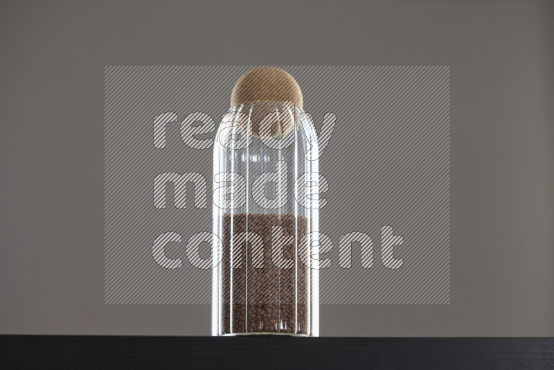 عدس بني في وعاء زجاجي على خلفية سوداء