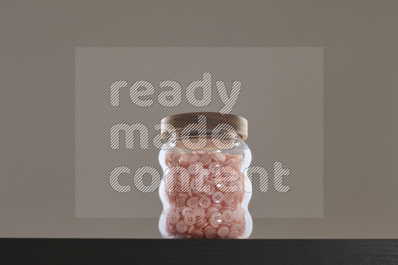 Buttons in a glass jar on black background