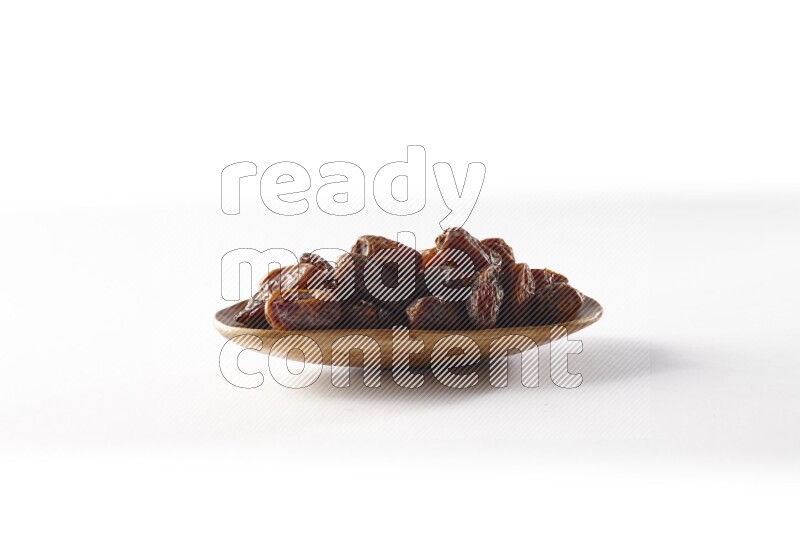 Dates in a wooden plate on white background