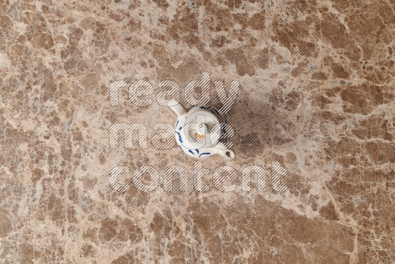 إبريق شاي فخاري على خلفية رخام بيج