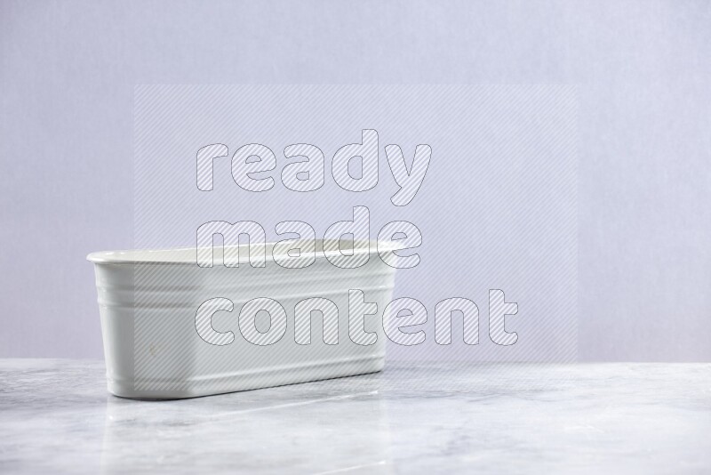 An empty white plant pot on grey marble background