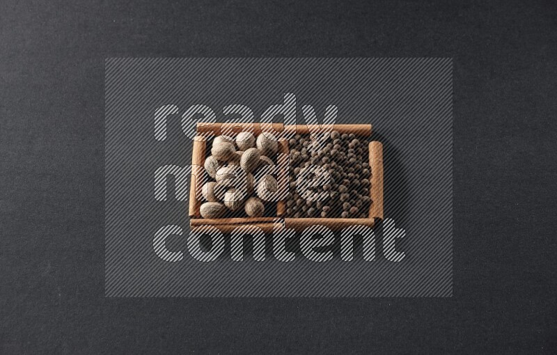 2 squares of cinnamon sticks full of nutmegs and allspice on black flooring