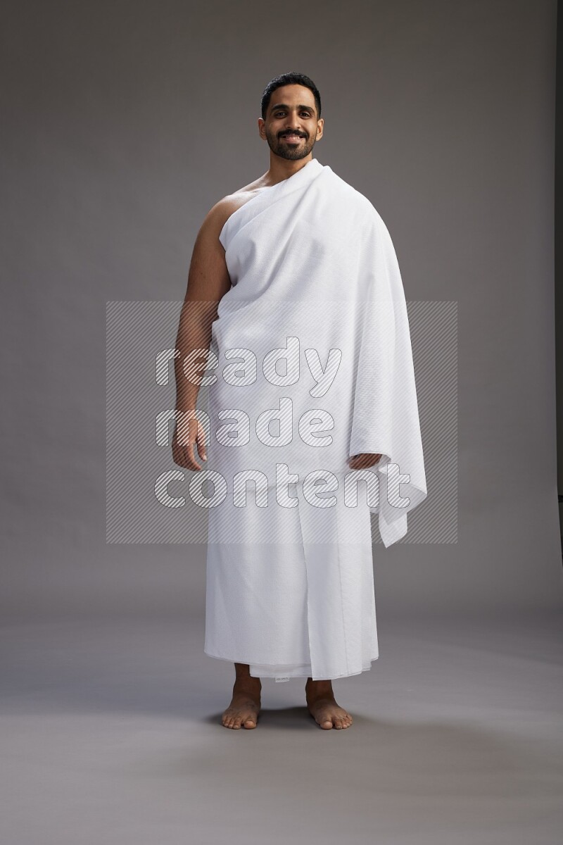 A man wearing Ehram Standing Interacting with the camera on gray background