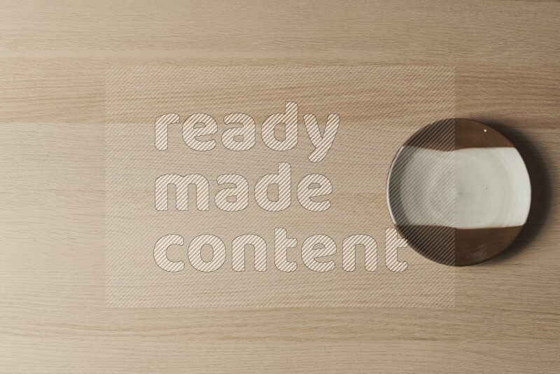 A multicolored pottery plate on light wooden background