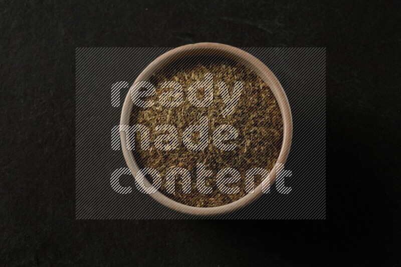 multi color round sauce bowl filled with herbs on grey textured countertop