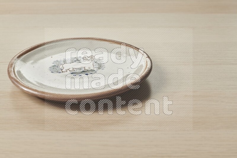A decorative pottery plate on light wooden background