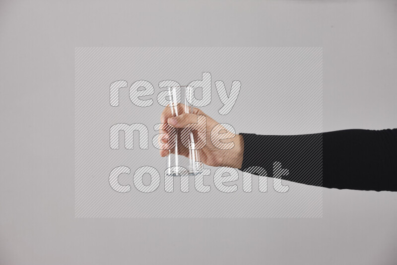 A woman in black abaya holding different glassware in different positions