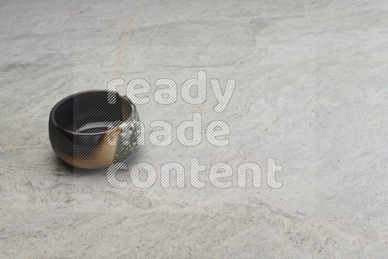 A multicolored pottery bowl on grey marble background