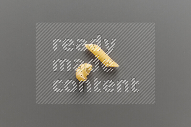Pipe pasta with other types of pasta on grey background