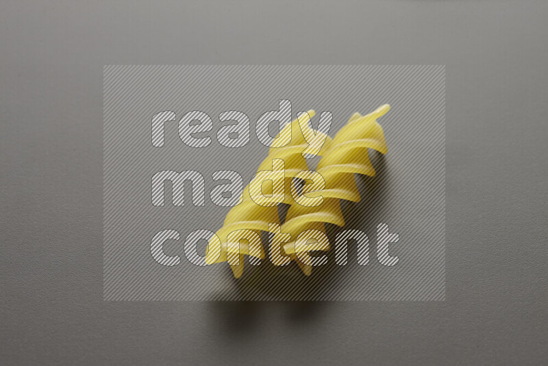 Fusilli pasta on grey background