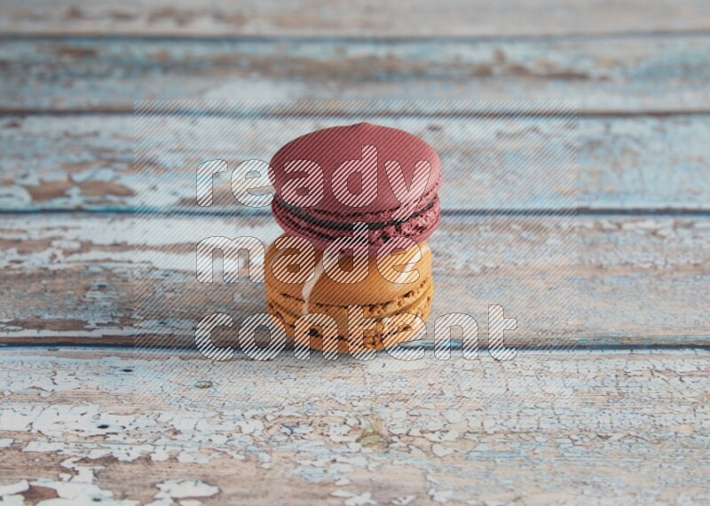 45º Shot of of two assorted Brown Irish Cream, and Red Cherry macarons  on light blue background