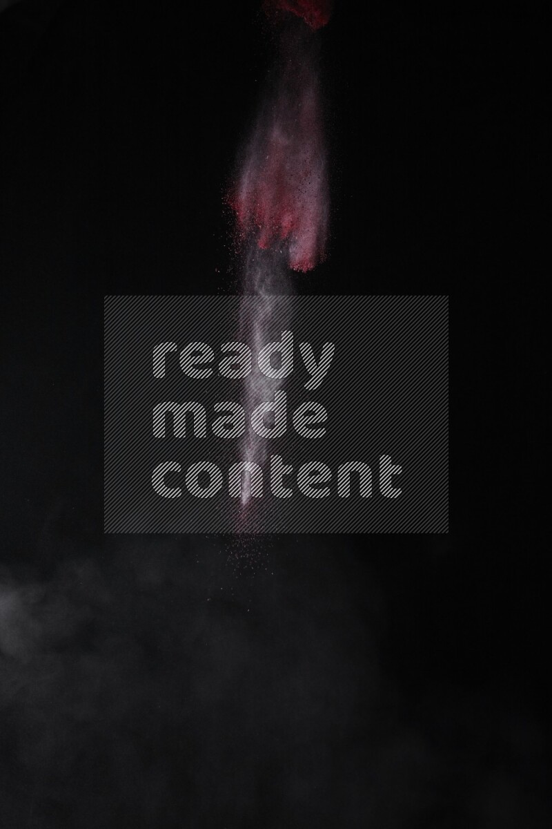 A side view of red powder explosion on black background
